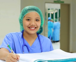 smiling nurse recording in patients logbook